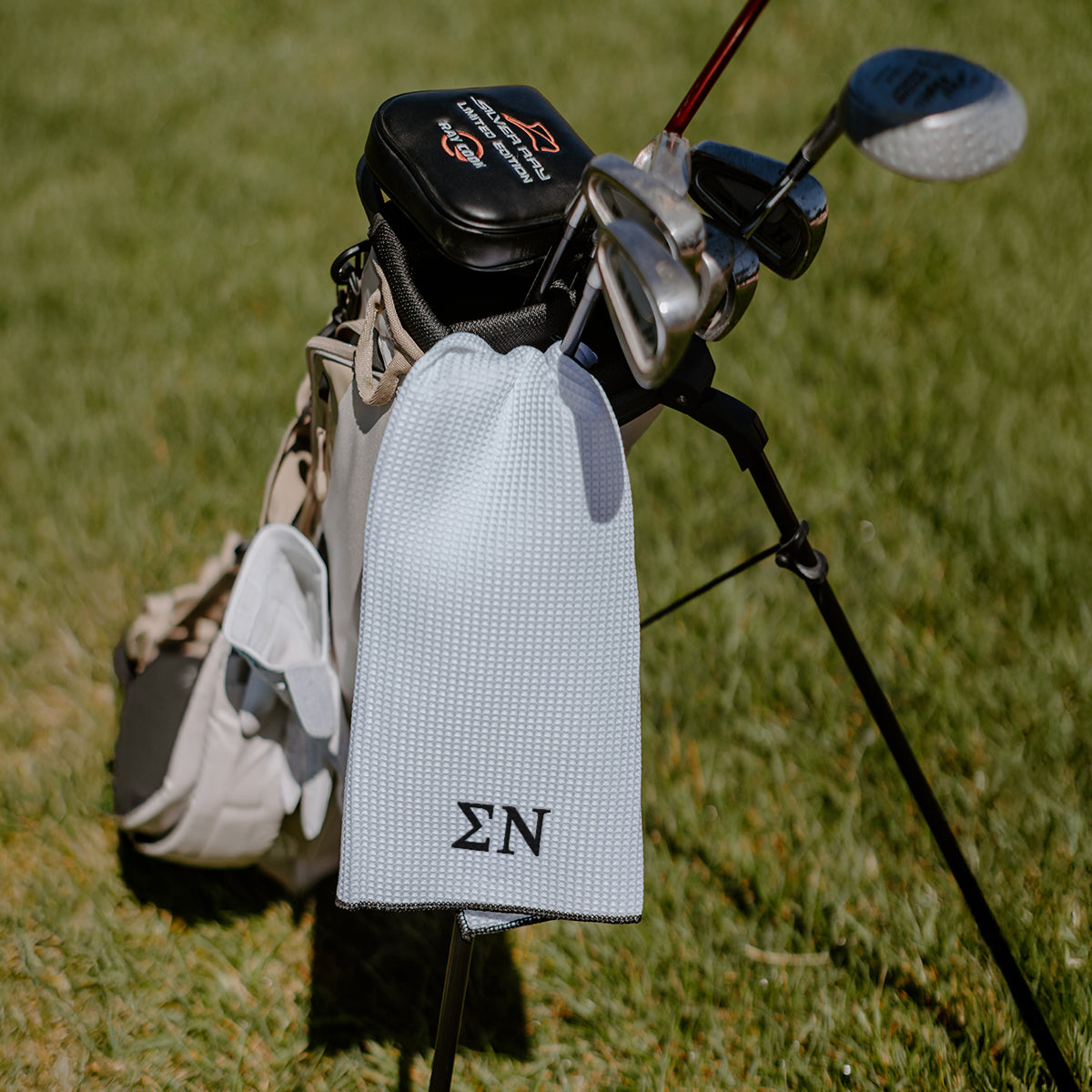 Sigma Nu Greek letters embroidered on a white golf towel.
