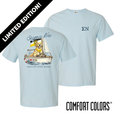 Light blue Comfort Colors t-shirt shown front and back; front features small Greek letters on the left chest, back displays a golden retriever sailing a boat with script text above and “Chasing Open Water” below.
