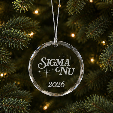 Limited Edition glass Christmas ornament with engraved design hanging on a decorated holiday tree