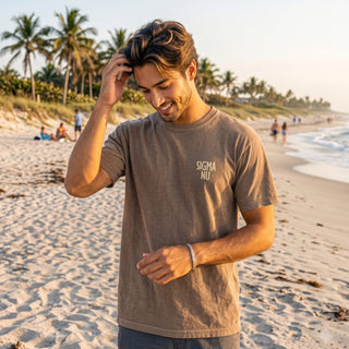 Model wearing the Surf Club Social T-shirt from the back while walking on a beach.