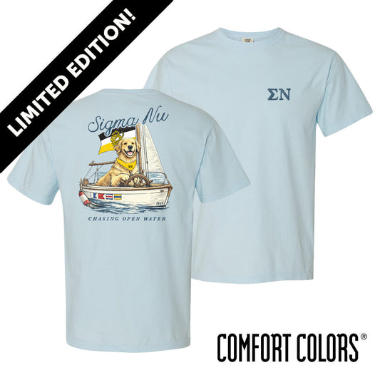 Light blue Comfort Colors t-shirt shown front and back; front features small Greek letters on the left chest, back displays a golden retriever sailing a boat with script text above and “Chasing Open Water” below.